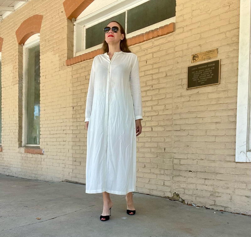 a woman in a white shirt dress and black heels