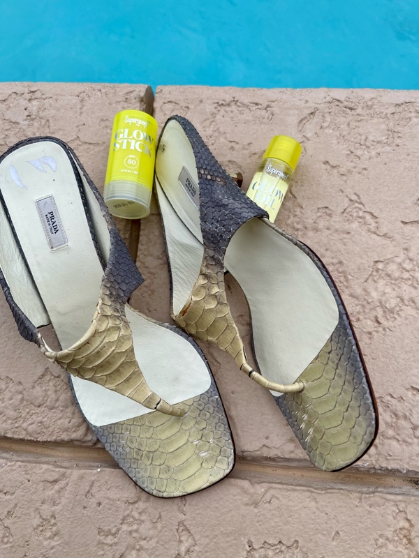 a close up of mini SuperGoop SPF and snake sandals