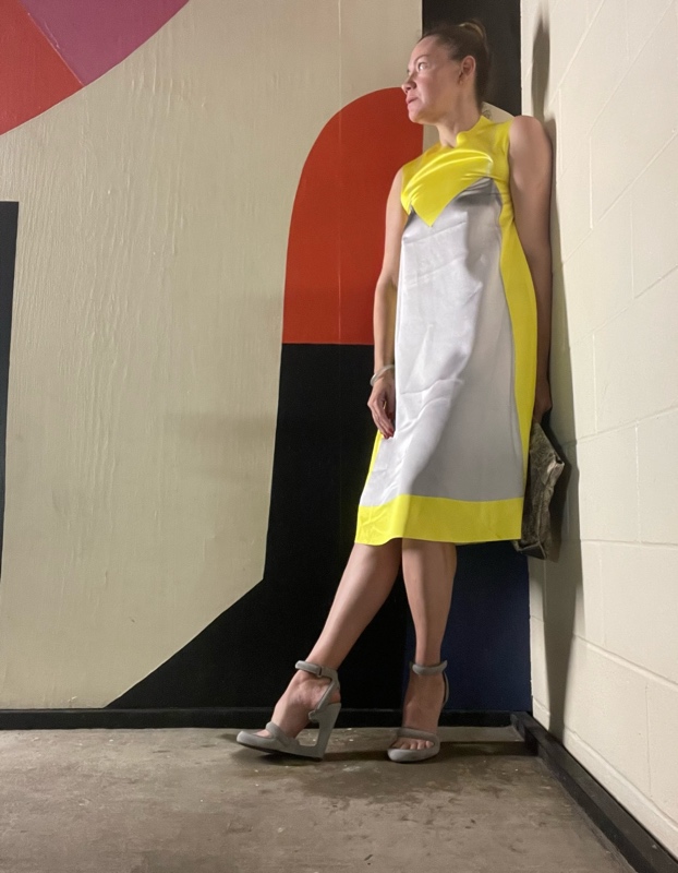 a woman in yellow and grey dress with grey platforms 